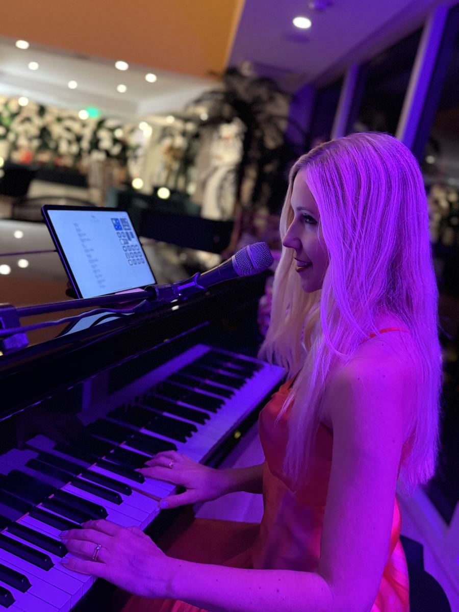 Joanna Holstein playing a grand piano at a lounge